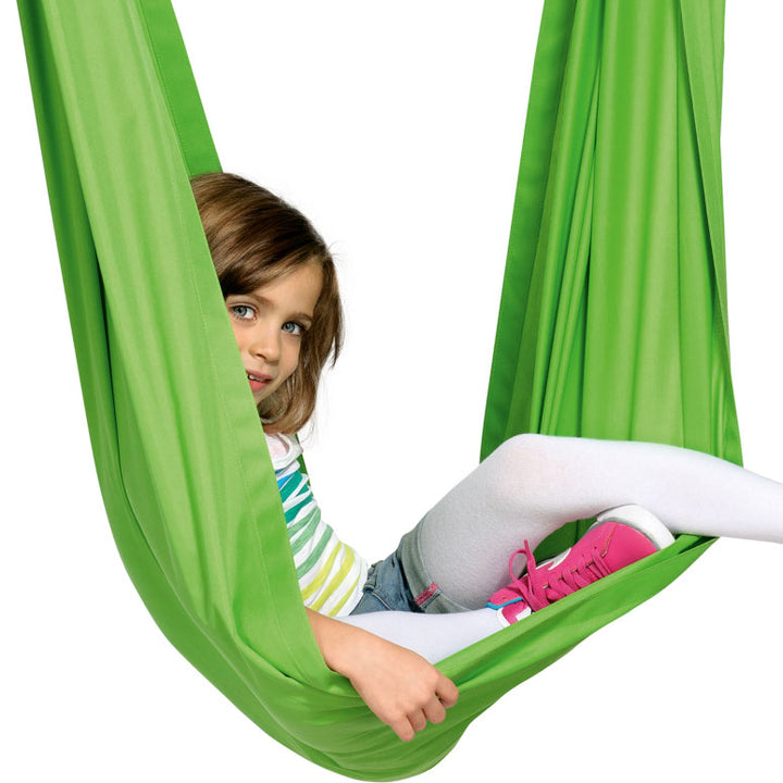 Child sitting in a green hammock against a white background